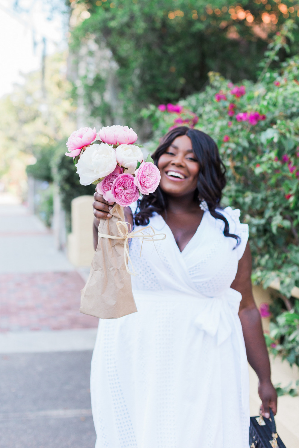 Black woman holding bouquet of pink peonies. Black woman holding bouquet